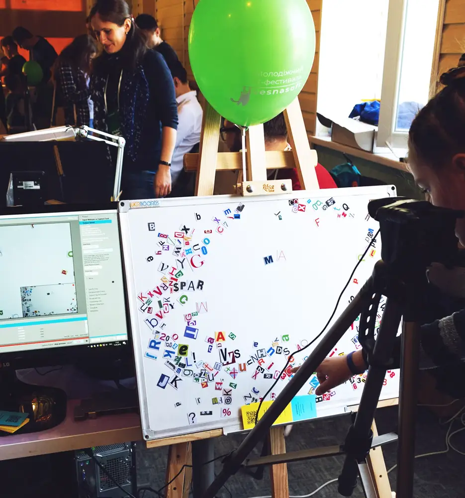 Open space lumineux avec plusieurs bureaux équipés, chaises ergonomiques, lampes de travail et grandes cloisons vitrées pour la confidentialité.