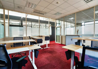 Espace de travail de 25m² pouvant accueillir jusqu’à 6 personnes, équipé de bureaux réglables en hauteur, fauteuils ergonomiques et cloisons vitrées.