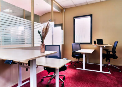 Bureau privatif de 15m² équipé de 4 postes de travail, chaises confortables et mobilier ergonomique, avec lumière naturelle et cloisons vitrées.