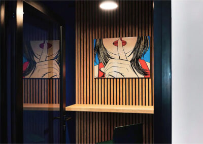 Phone box insonorisée avec tabourets et décoration murale pop art, idéale pour passer ses appels en toute tranquillité.