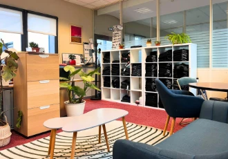 Un bureau aménagé sur-mesure par une entreprise, avec étagères, tables, canapé, table basse, tapis...