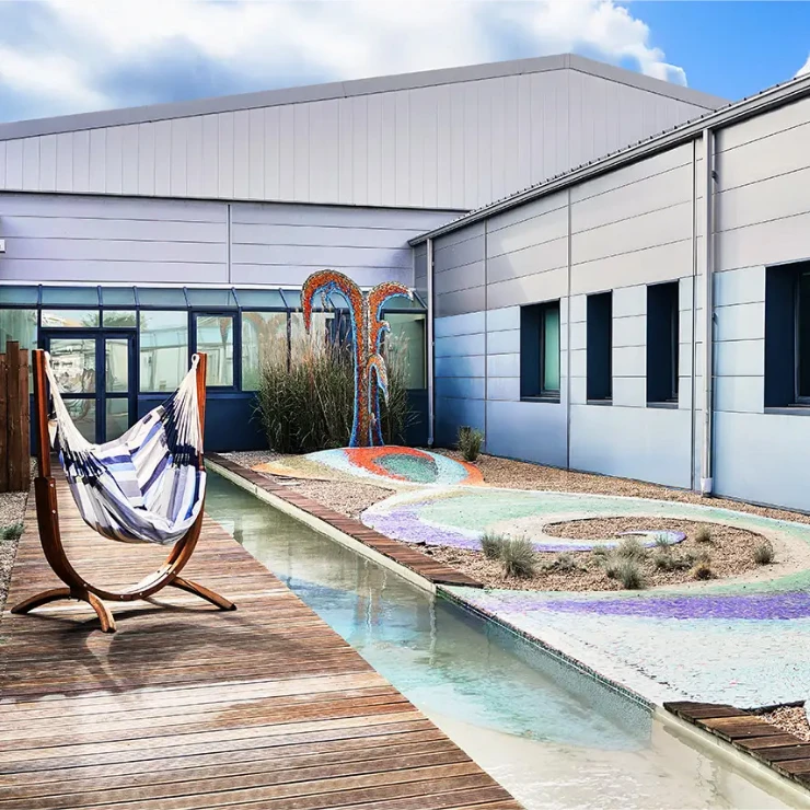 04-patio-la-passerelle-740x740 Vue du grand salon dans la longueur, avec l'aperçu de plusieurs espaces : petits salons, table pour travailler, phone box. Un espace lumineux et ouvert sur patio et jardin