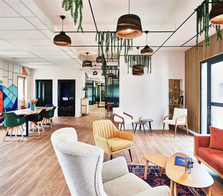 Vue du grand salon dans la longueur, avec l'aperçu de plusieurs espaces : petits salons, table pour travailler, phone box. Un espace lumineux et ouvert sur patio et jardin Vue du grand salon dans la longueur, avec l'aperçu de plusieurs espaces : petits salons, table pour travailler, phone box. Un espace lumineux et ouvert sur patio et jardin